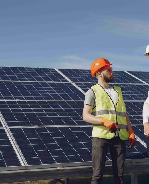 Businessman and worker near solar energy batteries. Business client showing photovoltaic detail to foreman. Two men making deal.